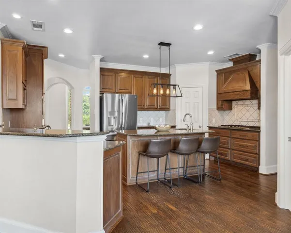 a kitchen with stainless steel appliances kitchen island granite countertop a sink and cabinets