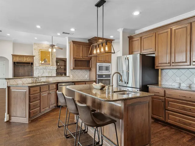 a kitchen with stainless steel appliances granite countertop a sink stove and refrigerator