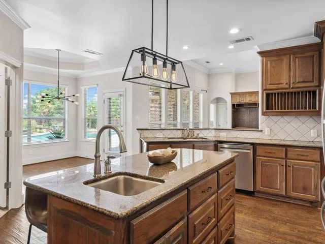 a kitchen with granite countertop a sink and cabinets