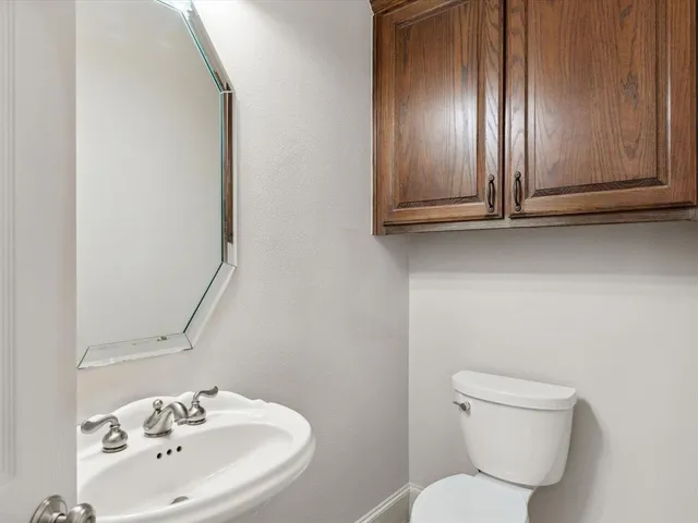 a bathroom with a toilet sink and mirror