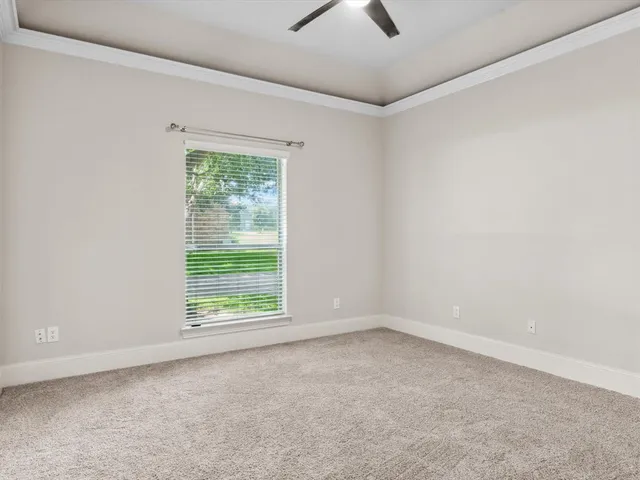 an empty room with a window and a ceiling fan