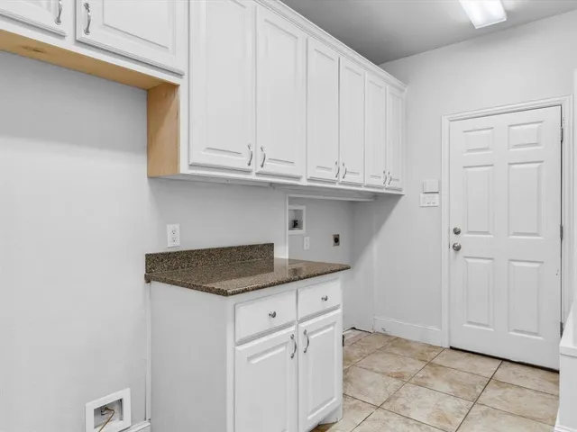 a kitchen with granite countertop white cabinets and a sink