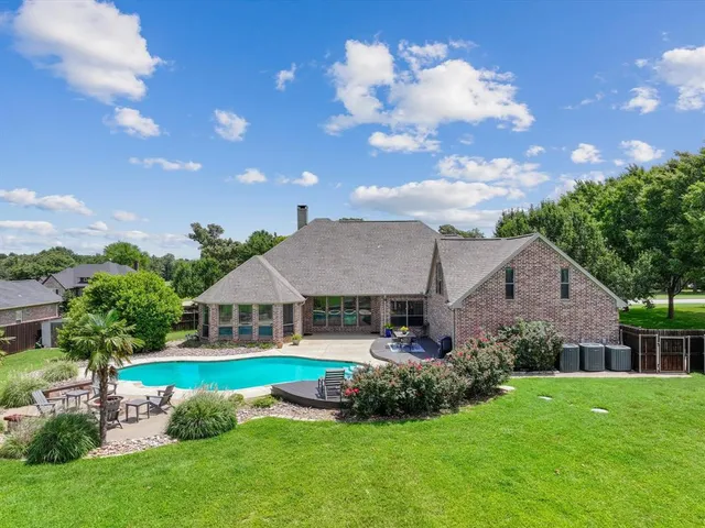 a view of house with garden space and swimming pool