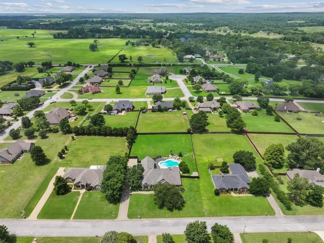 an aerial view of a house with a garden and lake view