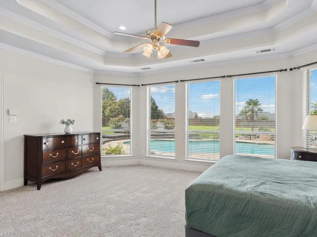 a bedroom with a bed and a large window