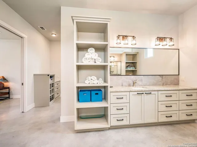a bathroom with a granite countertop sink and a mirror