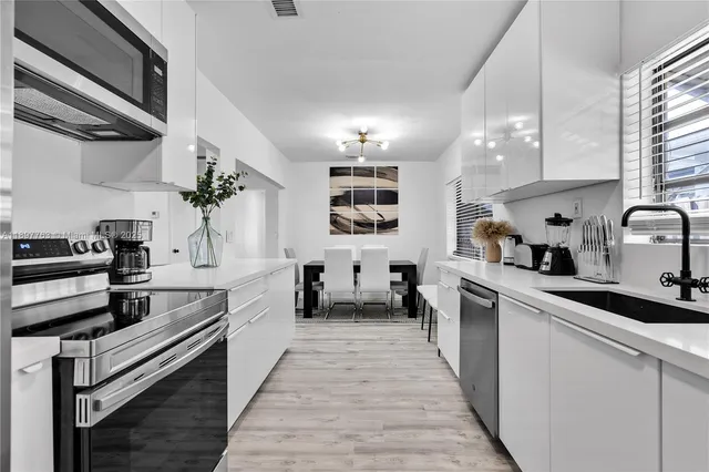 a kitchen with kitchen island granite countertop lots of counter top space and stainless steel appliances