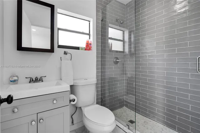 a bathroom with a sink a toilet and a mirror