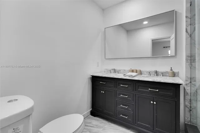 a bathroom with a toilet a sink and mirror