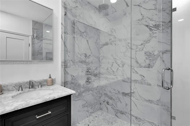 a bathroom with a granite countertop sink a toilet and shower
