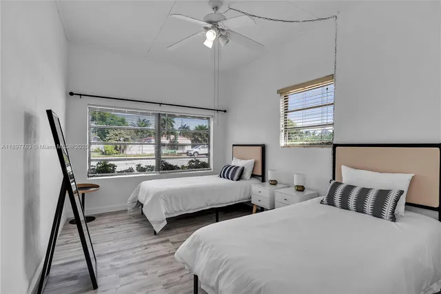 a bedroom with two beds and a night stand