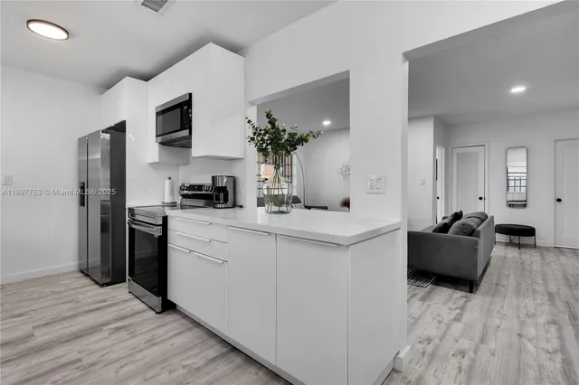 a kitchen with stainless steel appliances a sink dishwasher stove refrigerator and microwave