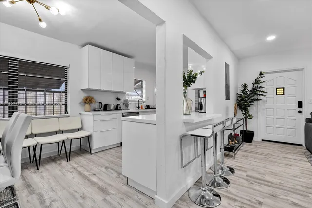 a view of kitchen and dining room with furniture wooden floor and windows