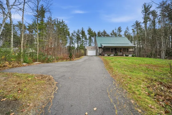 a front view of a house with a yard and trees