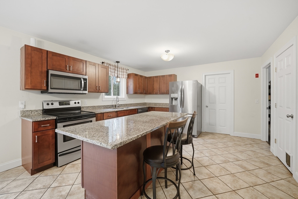 209 Osborne Road Ware, MA 01082 - Photo 9 of 32 a kitchen with stainless steel appliances granite countertop a stove refrigerator sink and microwave