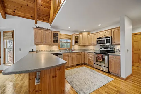a kitchen with granite countertop a sink cabinets stainless steel appliances and a counter top space