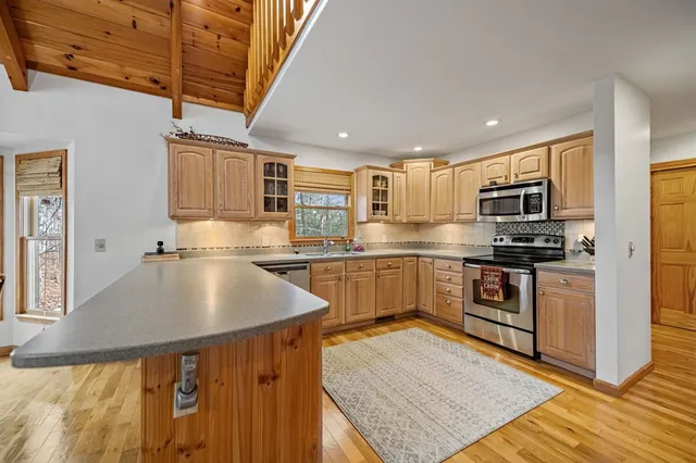 a kitchen with granite countertop a sink cabinets stainless steel appliances and a counter top space