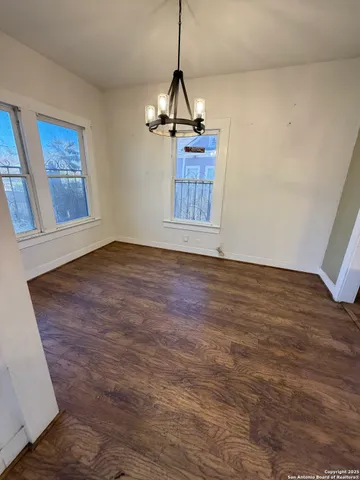 a view of a room with wooden floor a ceiling fan and window