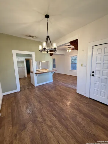 a view of a room with wooden floor fireplace and windows