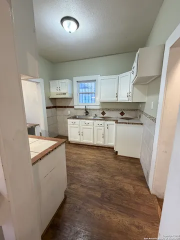 a kitchen with white cabinets and appliances