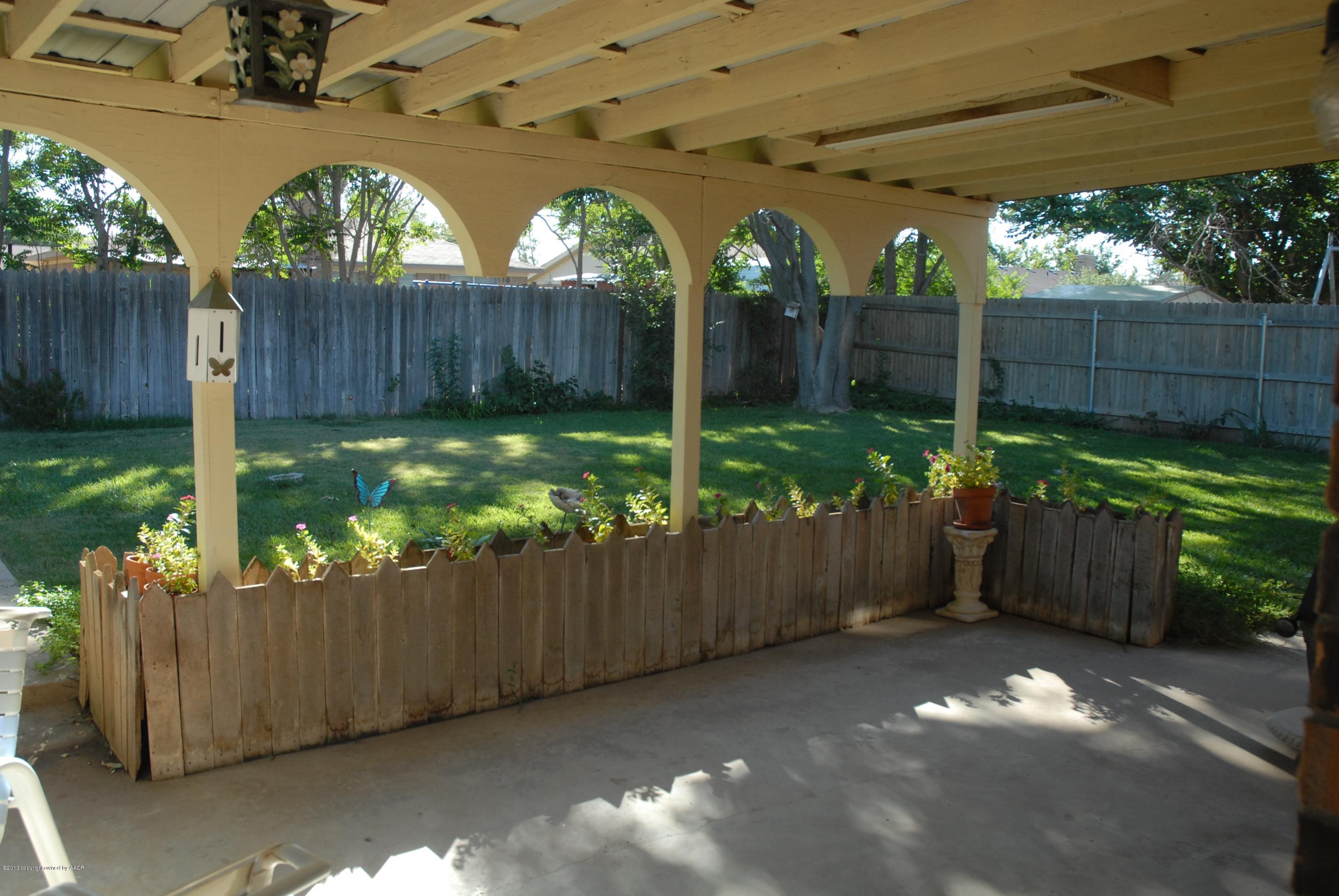 8207 Goodnight Trail Amarillo, TX 79110 - Photo 16 of 16 a view of a backyard with plants and wooden fence