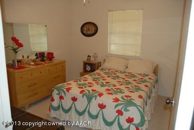 8207 Goodnight Trail Amarillo, TX 79110 - Photo 10 of 16 a bedroom with a bed and a chandelier