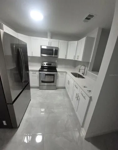 a kitchen with stainless steel appliances a refrigerator stove and sink