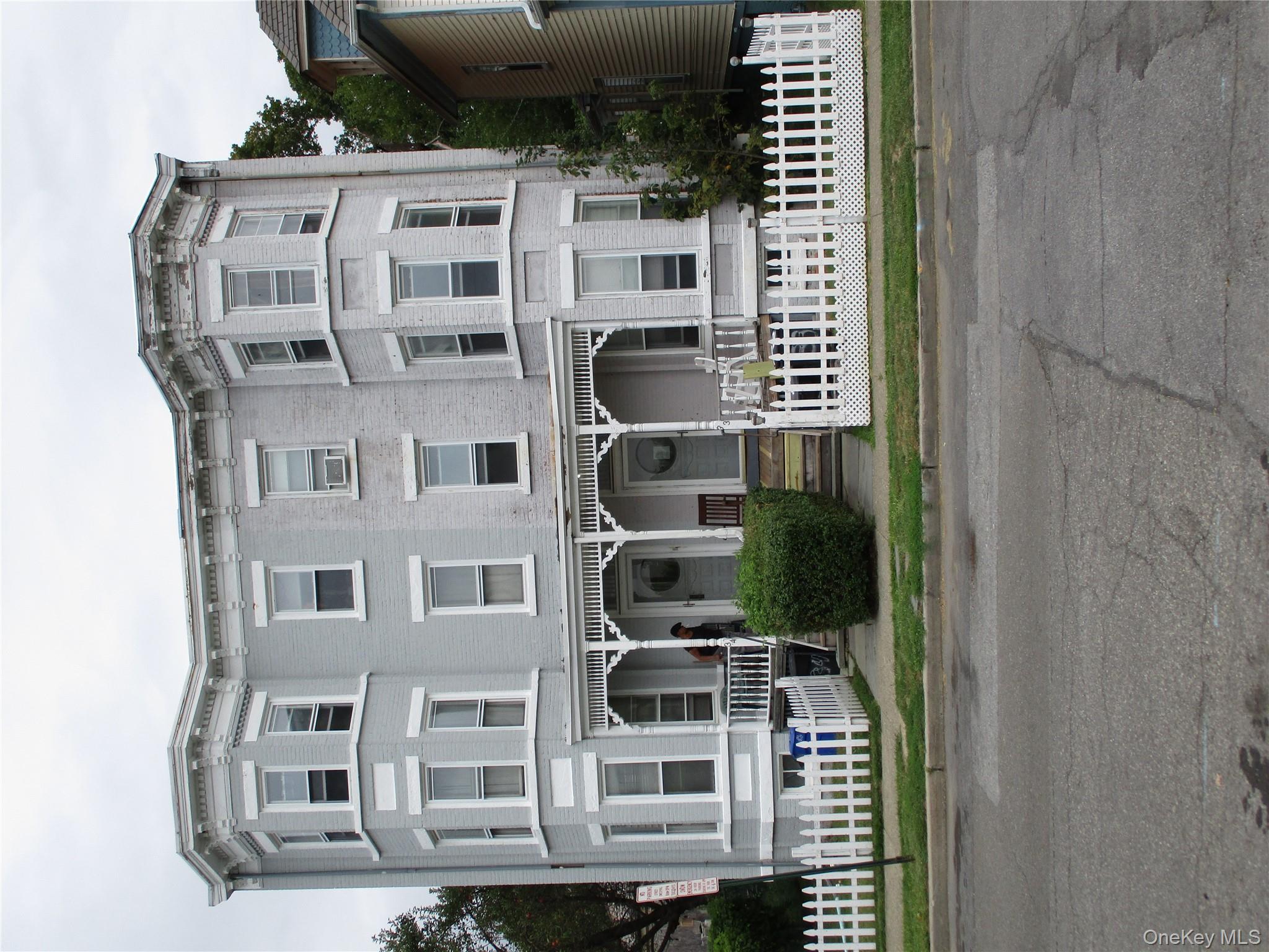 Italianate home with a fenced front yard and a porch