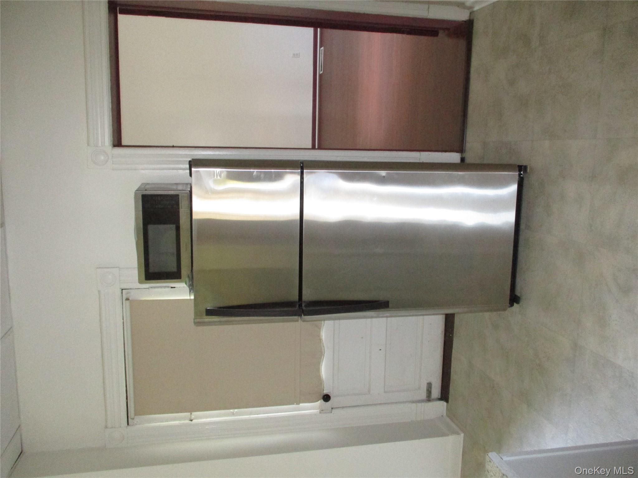 33 Bayview Terrace, Unit 1 Newburgh, NY 12550 - Photo 12 of 20 Kitchen featuring freestanding refrigerator, white cabinets, and light floors