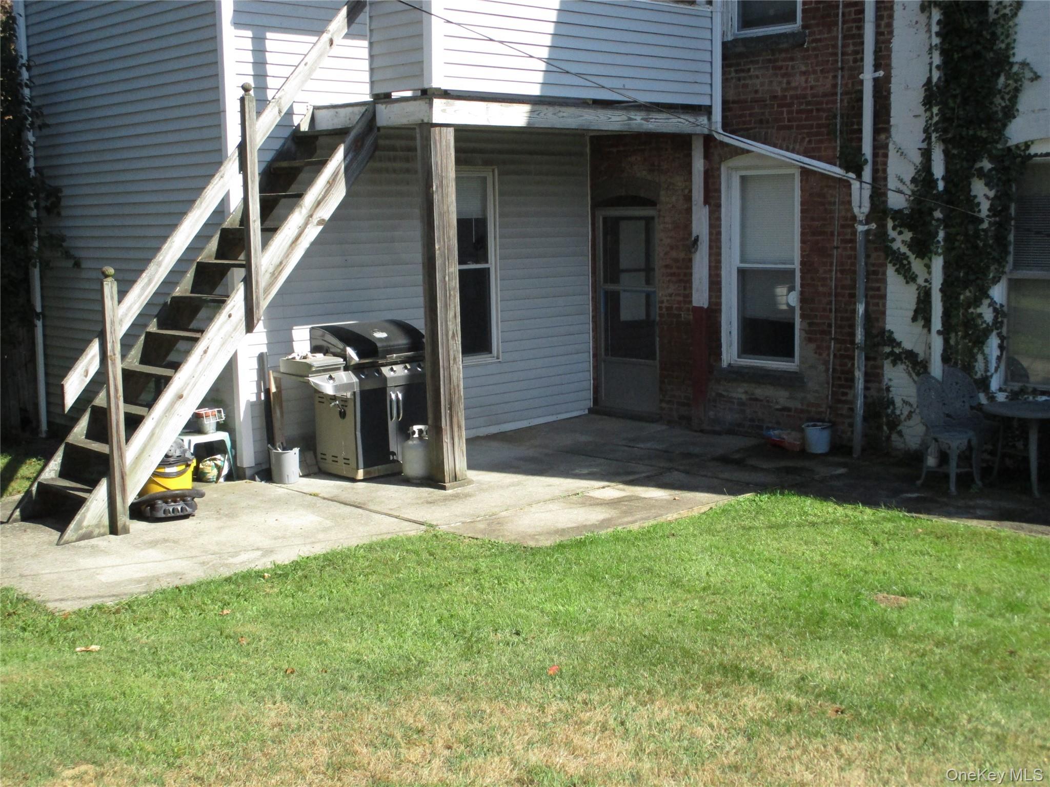 33 Bayview Terrace, Unit 1 Newburgh, NY 12550 - Photo 13 of 20 Rear view of property with a patio area, stairs, brick siding, and a yard