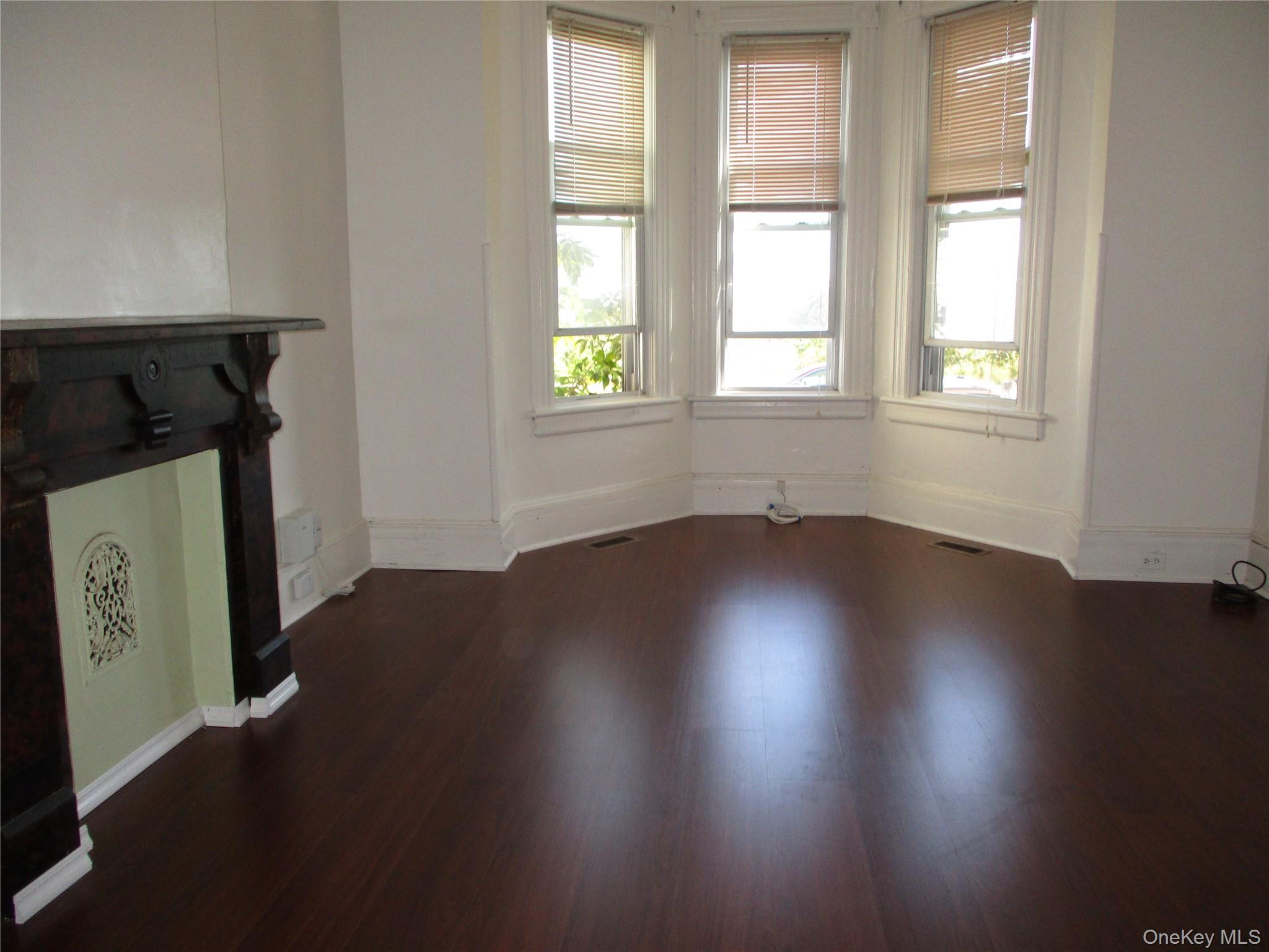33 Bayview Terrace, Unit 1 Newburgh, NY 12550 - Photo 4 of 20 Unfurnished living room with healthy amount of natural light and dark wood-type flooring