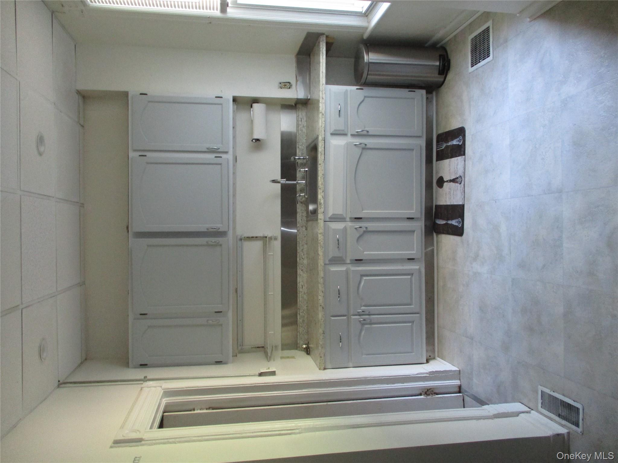 33 Bayview Terrace, Unit 1 Newburgh, NY 12550 - Photo 9 of 20 Kitchen with gray cabinetry, healthy amount of natural light, a paneled ceiling, and light flooring