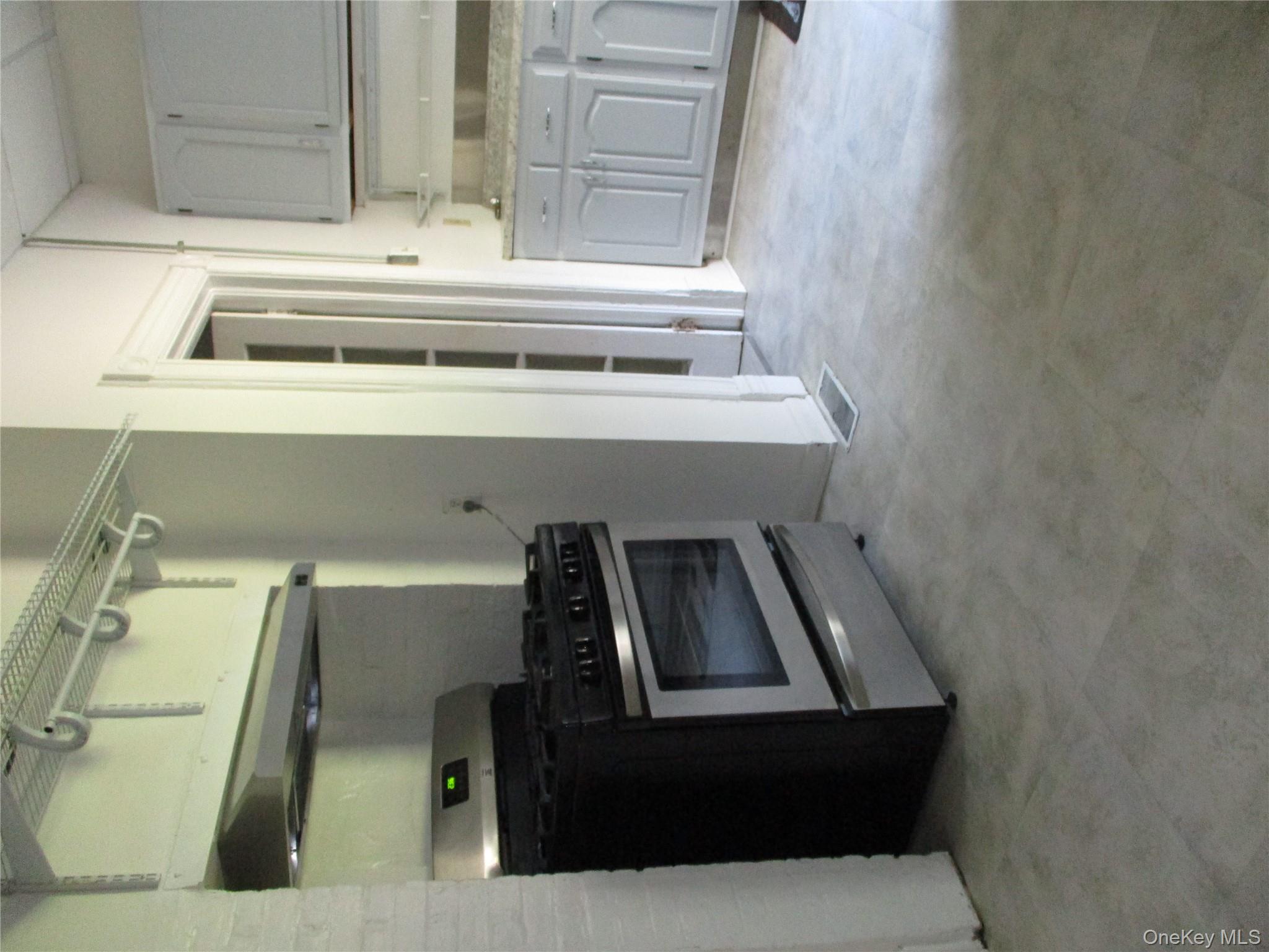 33 Bayview Terrace, Unit 1 Newburgh, NY 12550 - Photo 10 of 20 Kitchen with stainless steel range, exhaust hood, and gray cabinets
