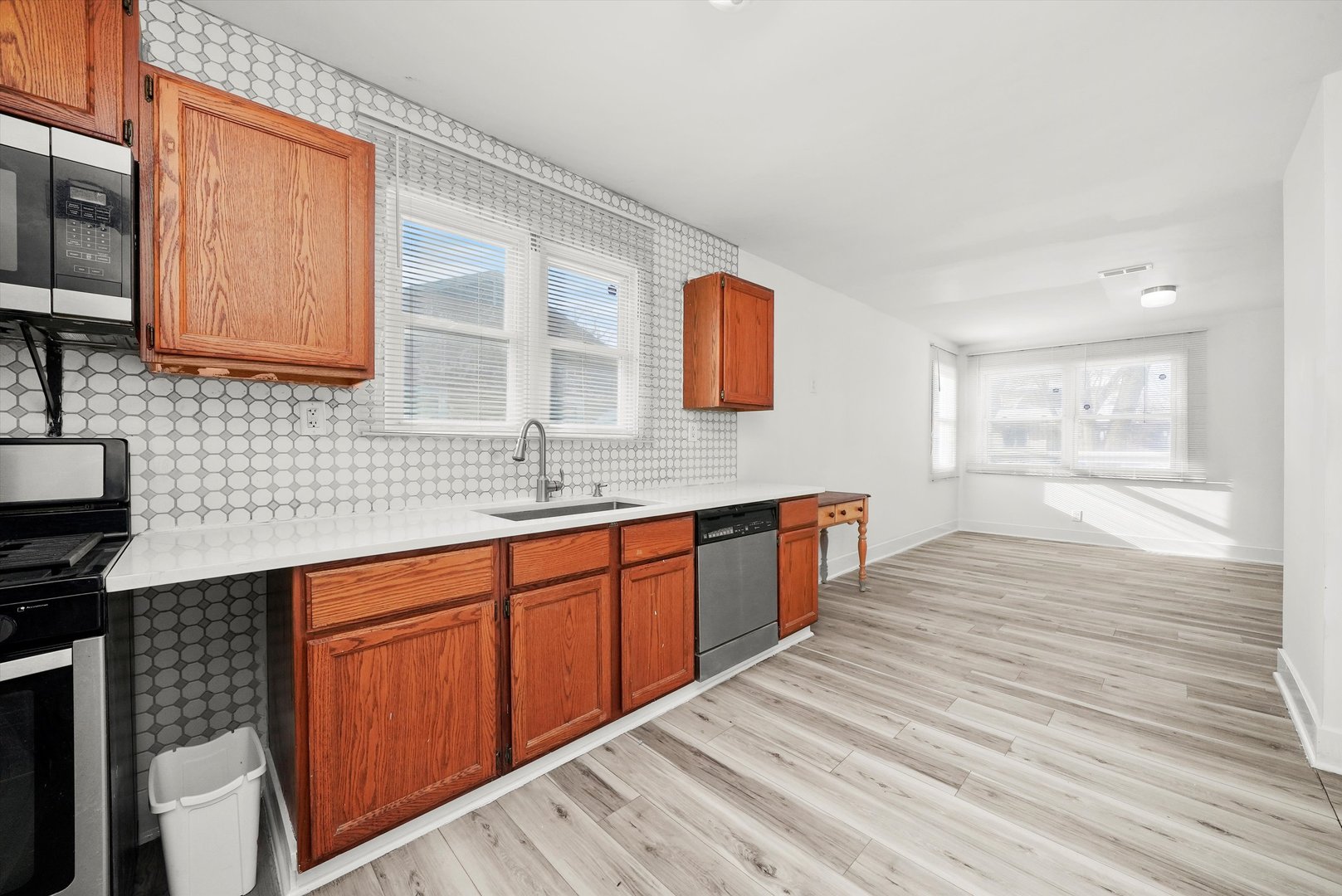 14525 Justine Street Harvey, IL 60426 - Photo 17 of 32 a large kitchen with stainless steel appliances granite countertop a sink and wooden cabinets