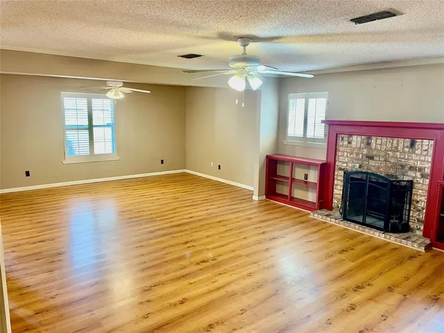 a view of an empty room with a window and fireplace