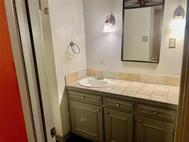 a bathroom with a sink a mirror and vanity