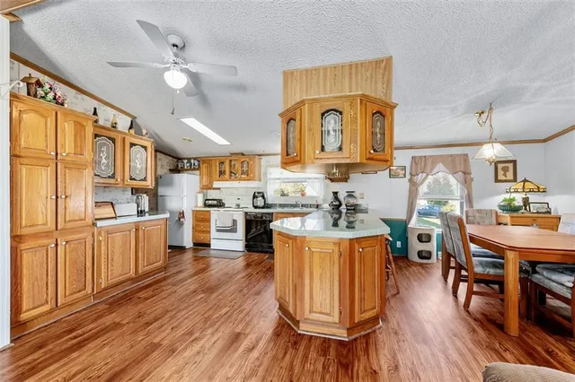 a living room with stainless steel appliances kitchen island granite countertop wooden floors and a view of living room