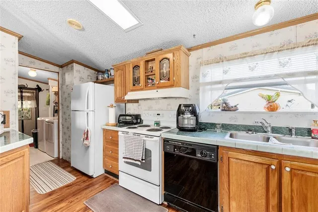 a kitchen with stainless steel appliances granite countertop a stove a sink and a refrigerator