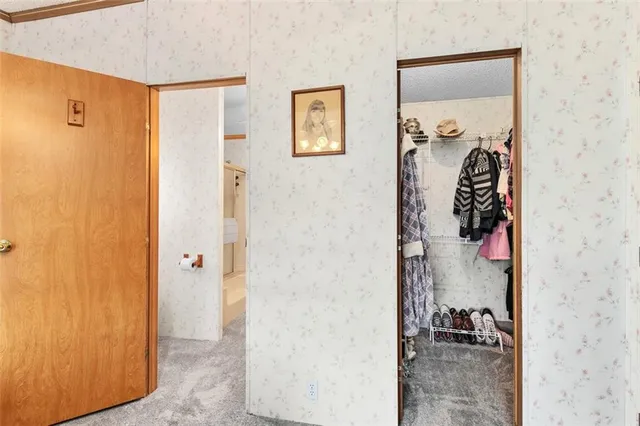 a view of a hallway with closet and a bathroom