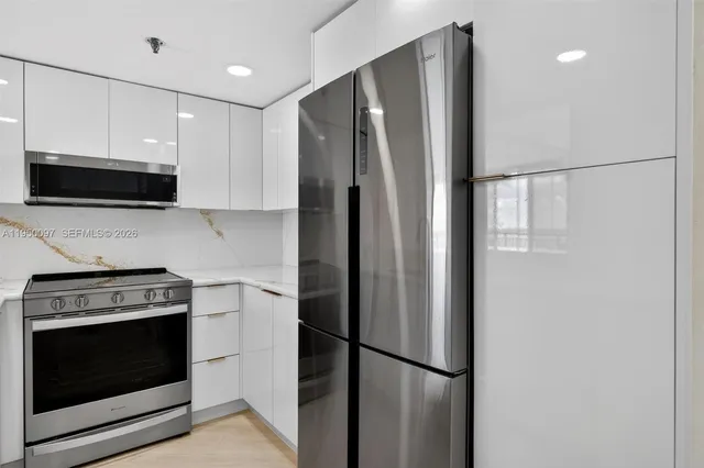 a kitchen with stainless steel appliances a refrigerator stove and microwave