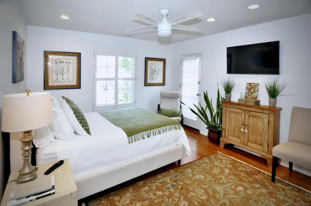 a bedroom with a bed a couch and a flat screen television