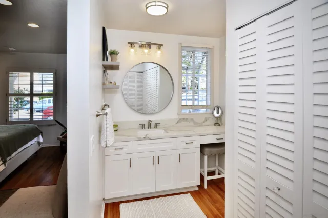 a en suite bathroom with a granite countertop sink and a mirror