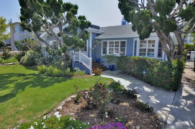 a front view of a house with a yard and green space