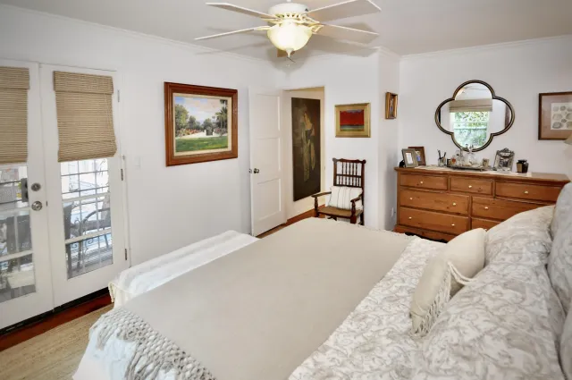 a bedroom with a large bed and wooden floor