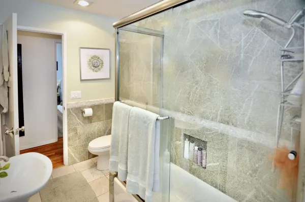 a bathroom with a granite countertop toilet sink and shower