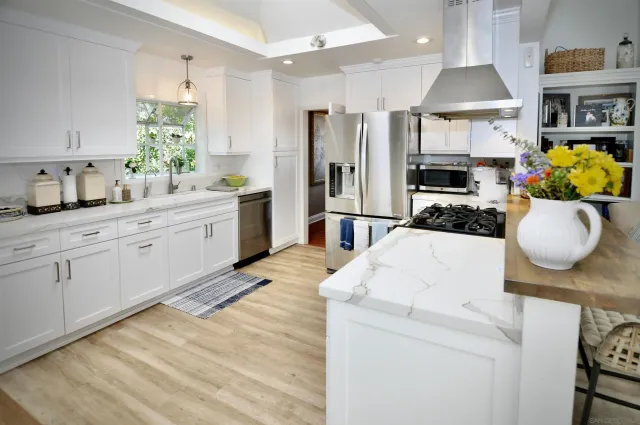 a kitchen with stainless steel appliances kitchen island granite countertop a stove a sink and a refrigerator