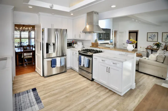 a kitchen with stainless steel appliances granite countertop a stove a refrigerator and white cabinets
