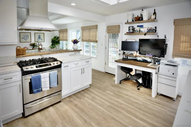 a kitchen with cabinets appliances and a wooden floor