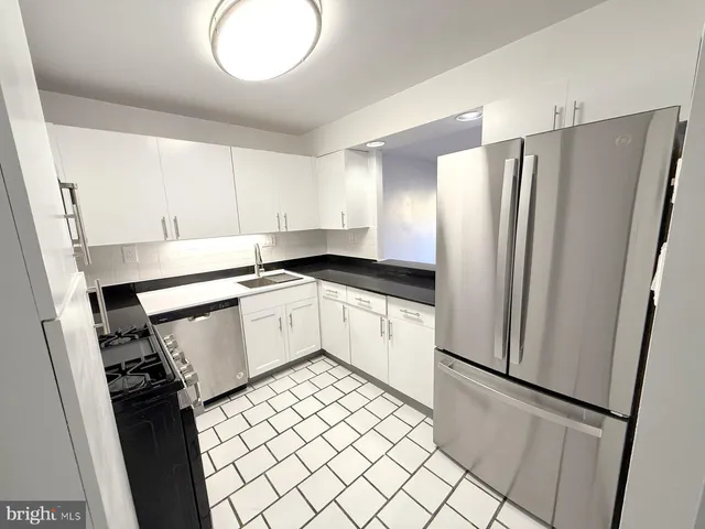 a kitchen with white cabinets appliances and a sink