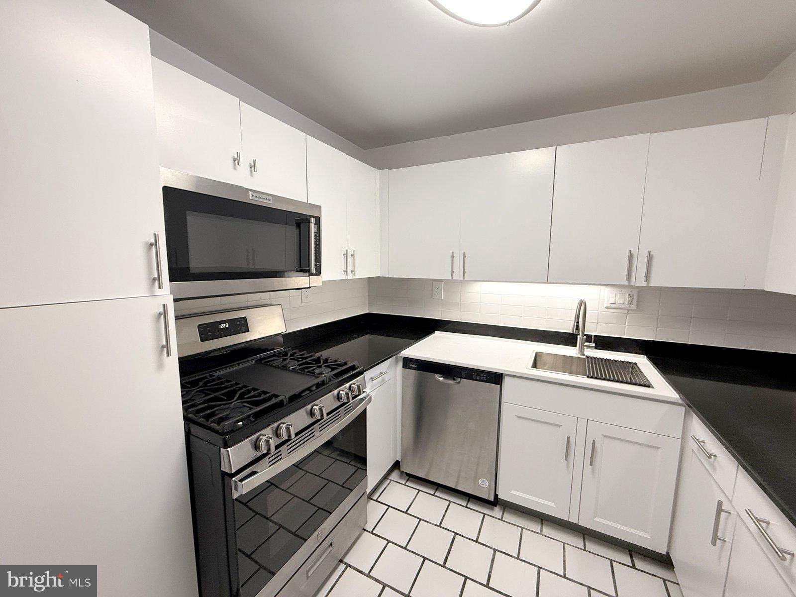 606 Cooper Landing Road, Unit A3E Cherry Hill, NJ 08002 - Photo 4 of 17 a kitchen with white cabinets appliances and a sink